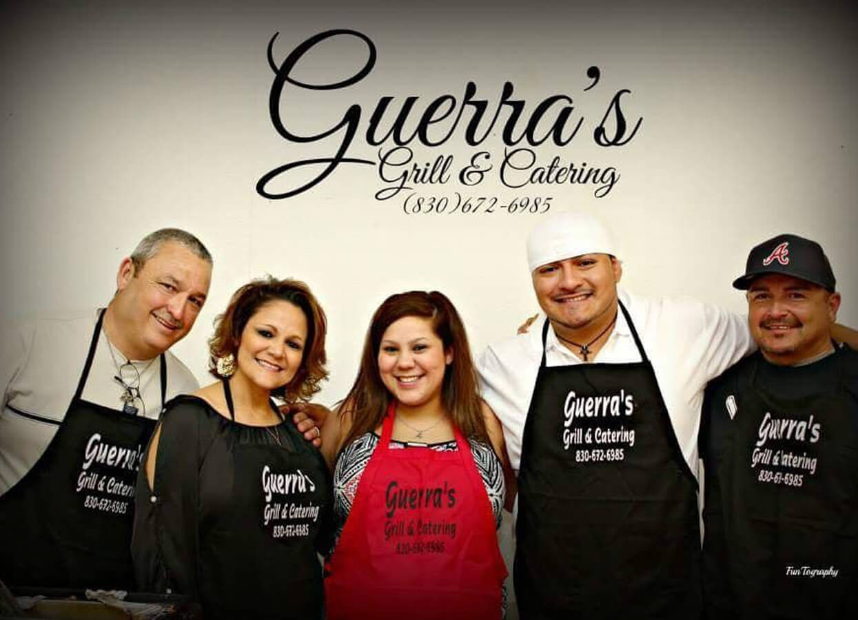 Showing the logo for Guerra's Grill and Catering. Staff members pose below the logo.