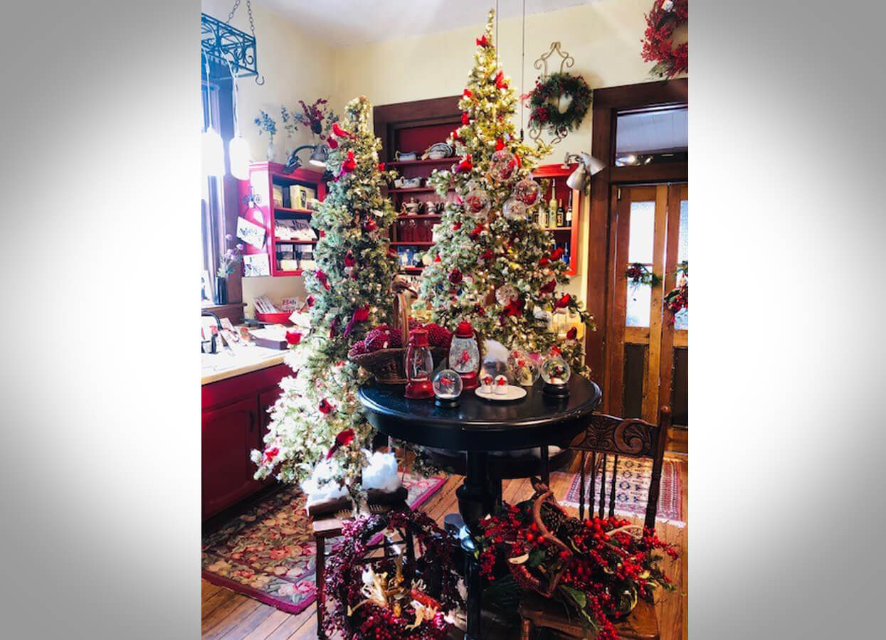 Showing two decorated artificial Christmas trees in Laurel Ridge Antiques.
