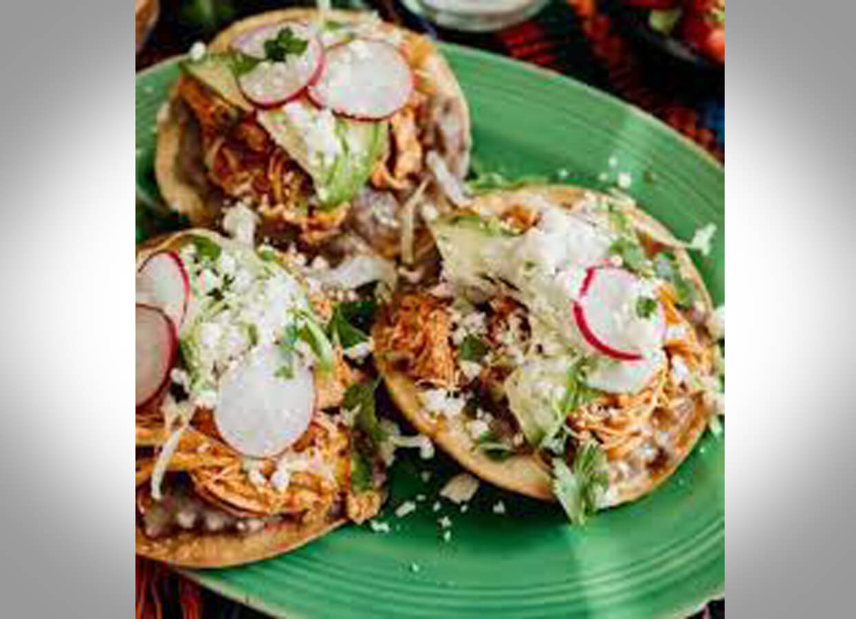 Showing three tacos on a green plate.